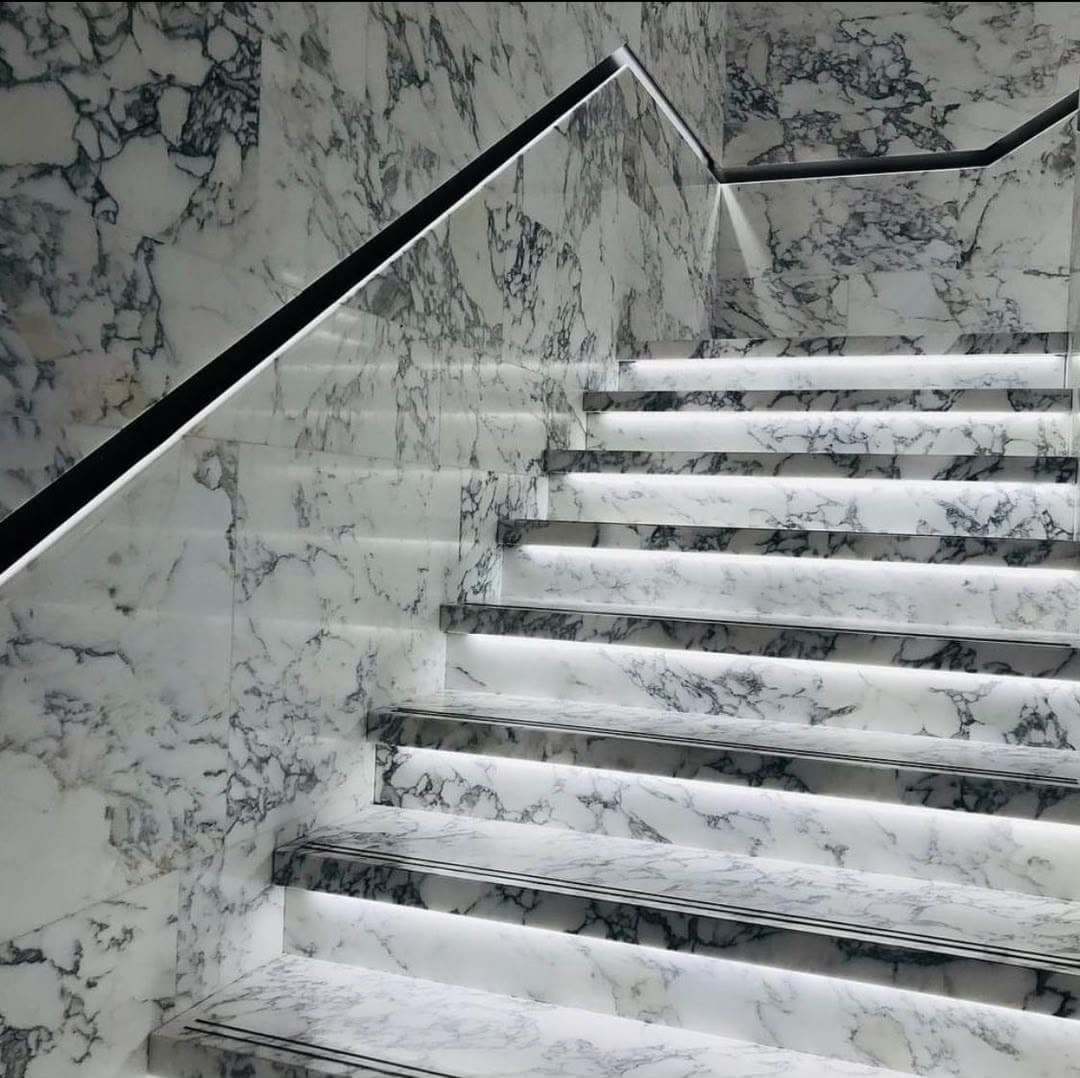 Escalier en marbre blanc veiné dont chaque marche est rétroéclairée